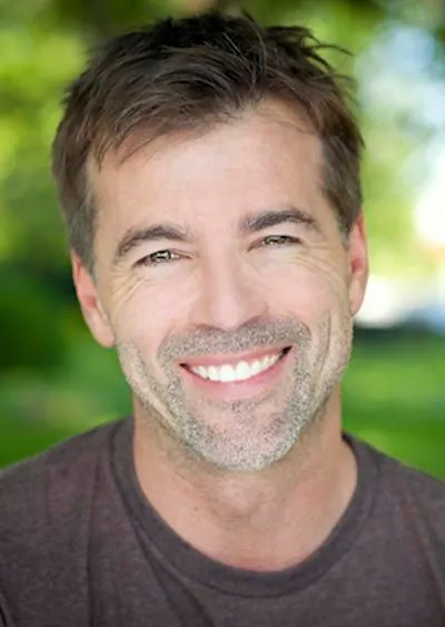 man showing off his restored smile thanks to dental implants